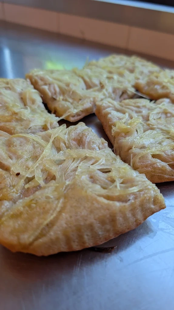 Tranci di pizza bianca con cipolle sul banco